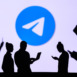 NEW YORK, USA, 1. MARCH 2022: ​​Telegram app, Group of business people chat on mobile phone and laptop. ​​Telegram – freeware, cross-platform, cloud-based instant messaging. Company logo on screen