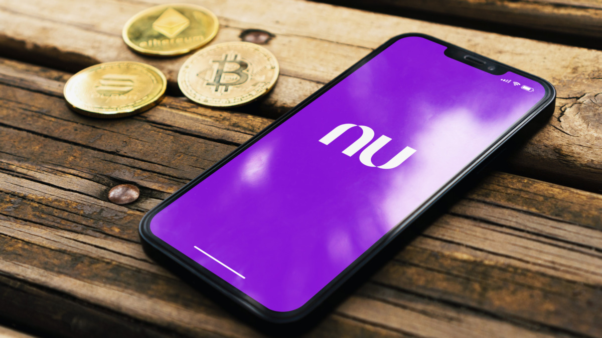 Nubank bank app on smartphone screen on rustic wooden table with a cryptocurrencies coins. Rio de Janeiro, RJ, Brazil. May 2022.