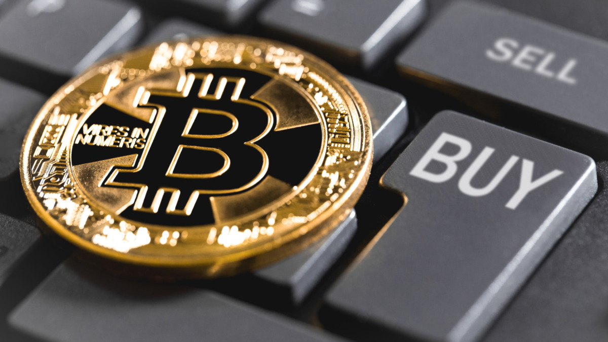 bitcoin and computer keyboard with buttons buy & sell