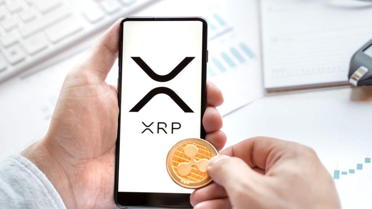 Russia Moscow 24.06.21 Logo of Ripple coin in mobile phone. Cryptocurrency XRP token. Trading blockchain platform to buy,sell on decentralized exchange DEX. Digital money.Business,investing.