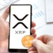 Russia Moscow 24.06.21 Logo of Ripple coin in mobile phone. Cryptocurrency XRP token. Trading blockchain platform to buy,sell on decentralized exchange DEX. Digital money.Business,investing.