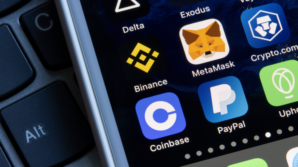Assorted cryptocurrency apps are seen on an iPhone, including Coinbase, PayPal, Uphold, Binance, MetaMask, Crypto.com, and Delta.