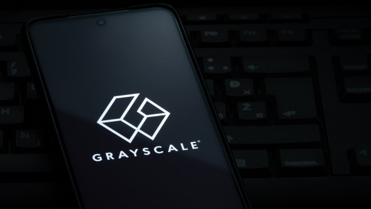 Grayscale investing logo on smartphone screen laying on computer keyboard