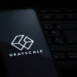 Grayscale investing logo on smartphone screen laying on computer keyboard