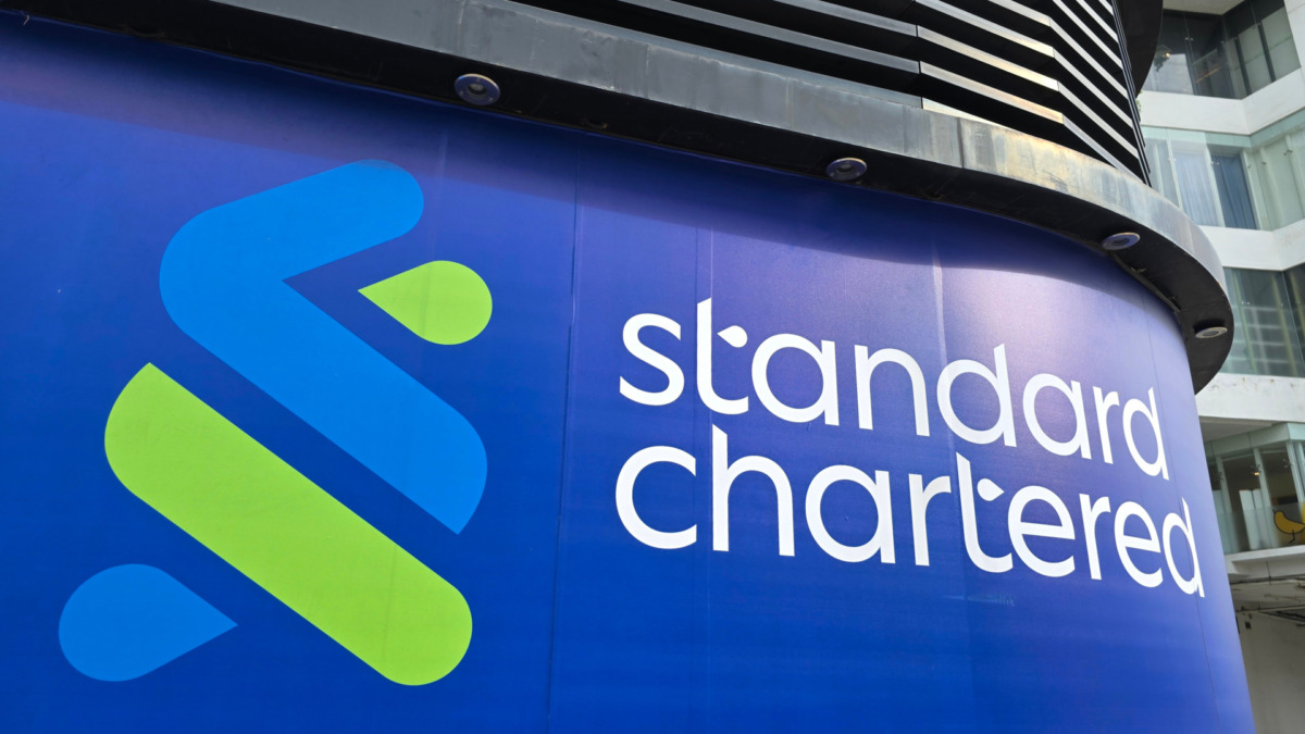 Close-up details of the Standard Chartered Bank logo and signage on the building exterior, showcasing the bank's modern branding.