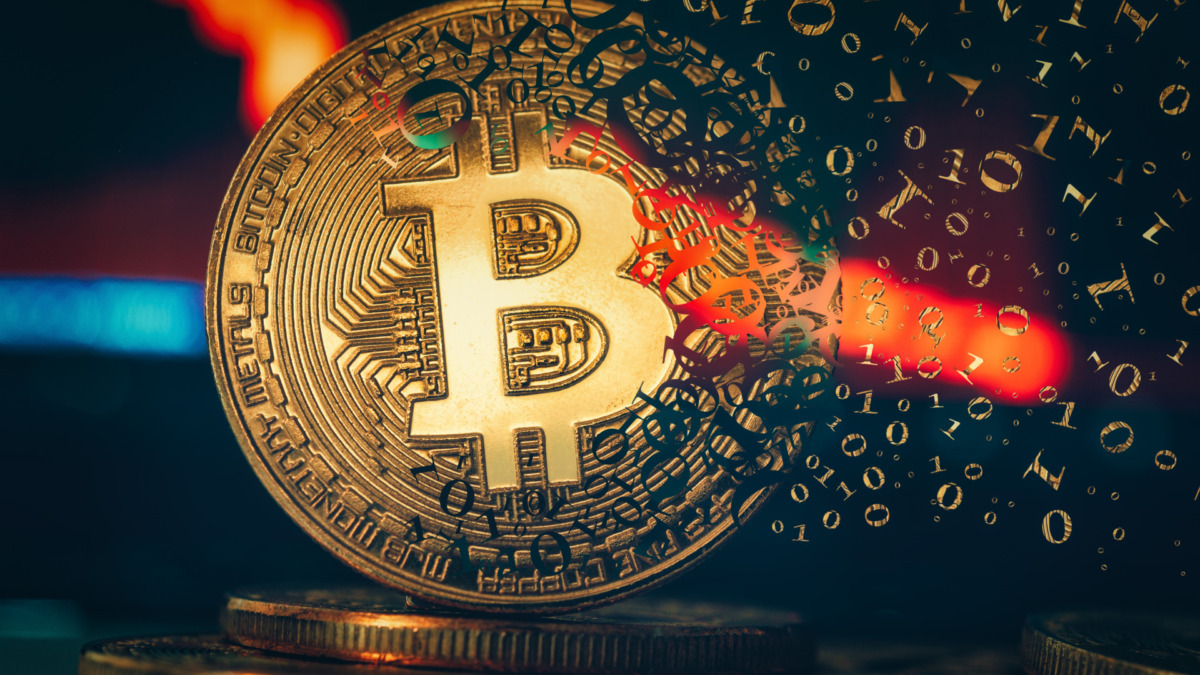 Crypto currency golden coin. Gold bitcoin falling apart. Concept of a cryptocurrency market crisis and defocused chart background.