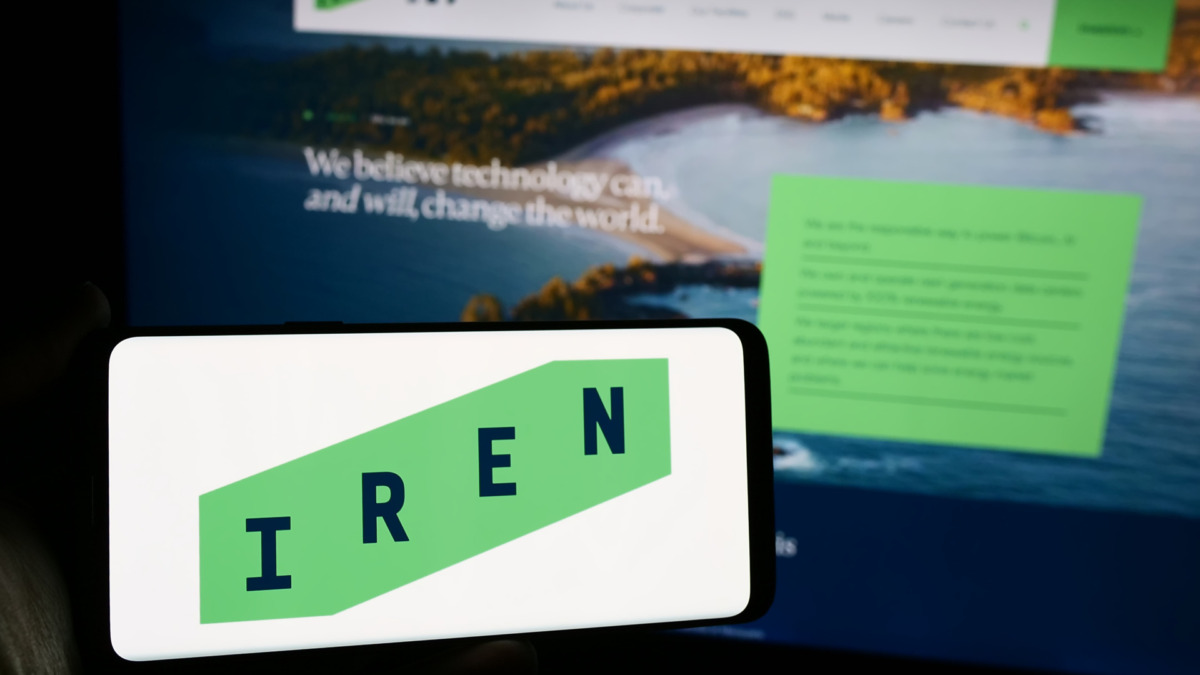 holding mobile phone with logo of Australian Bitcoin mining company Iris Energy Ltd. (IREN) in front of web page. Focus on phone display.