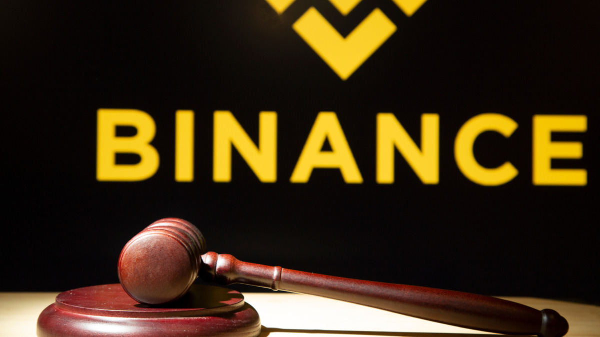 Binance and court session. Judicial hammer on the background of the logo.