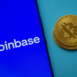Coinbase logo on smartphone screen near Bitcoin coin and QR code on blue background.