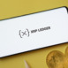 XRP Ledger logo on smartphone screen near Bitcoin coin and QR code on background.