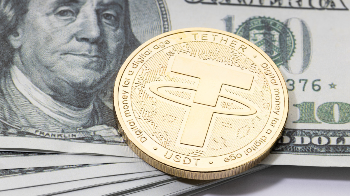 Tether USDT coin on stacked dollar banknotes. USDT dollar parity concept