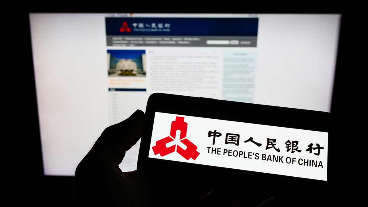Stuttgart, Germany - 09-19-2022: Person holding smartphone with logo of financial institution People's Bank of China on screen in front of website. Focus on phone display.