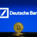 Bitcoin on a stack of coins with Deutsche Bank logo on a laptop screen