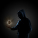 Golden Bitcoin floating above of hacker's hand in dark background. Finance, business, e-commerce or cyber crime concept