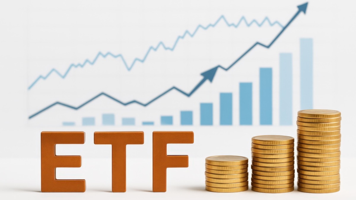 Wooden letters spelling "ETF" alongside increasing stacks of gold coins, set in front of a blurred upward trending financial chart.