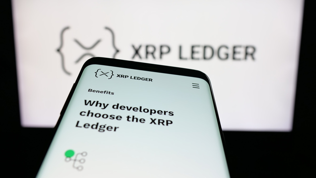 Mobile phone with website of cryptocurrency platform XRP Ledger (XRPL) on screen in front of logo. Focus on top-left of phone display.