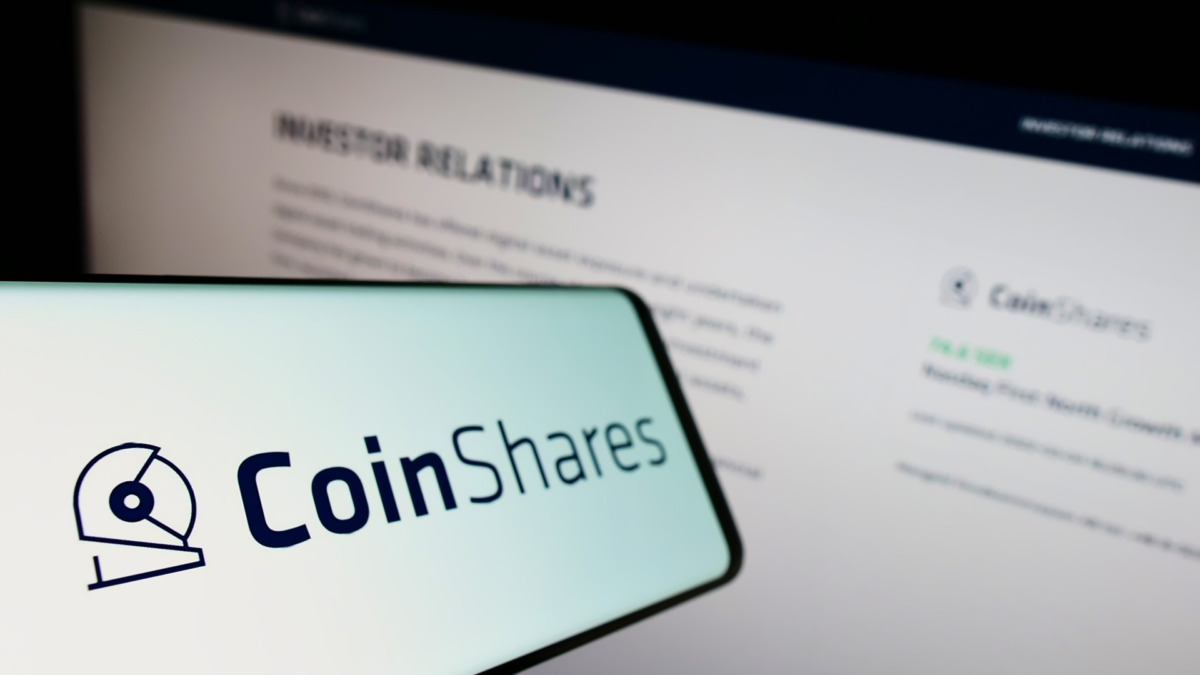 Smartphone with logo of British investment company CoinShares Group on screen in front of business website. Focus on left of phone display.
