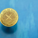 A golden Xrp cryptocurrency with intricate designs sits centered on a blue background, symbolizing the rise of digital currencies in contemporary finance and investment.