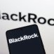 In this photo illustration, the BlackRock, Inc. logo is displayed on a smartphone and in the background