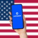 A hand holding a smartphone and the coinbase app logo. The USA flag in the background. coinbase Application Logo. Technology concept. Close up.