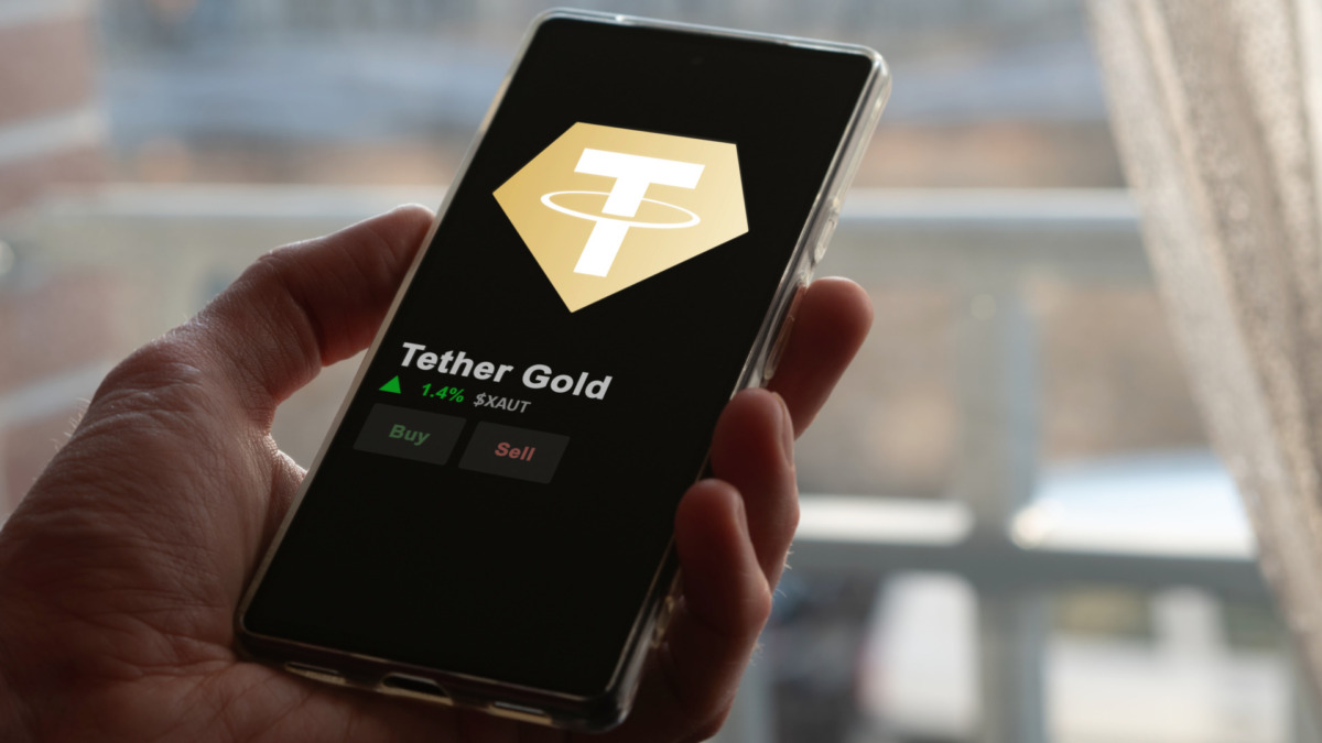 An investor analyzing the price of Tether Gold, the token coin $XAUT on a crypto exchange sreen.