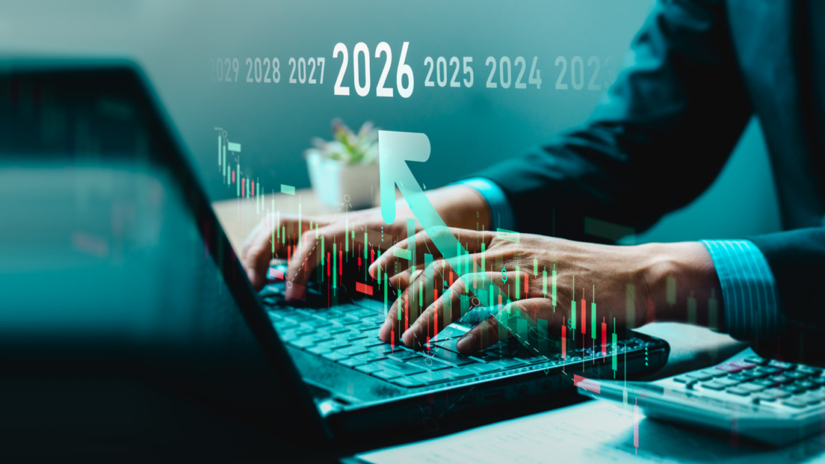 Businessman analyzing cryptocurrency and stock market trends on laptop with digital candlestick chart, rising arrow, and timeline to 2026. Concept of fintech, trading strategy, and financial forecast.
