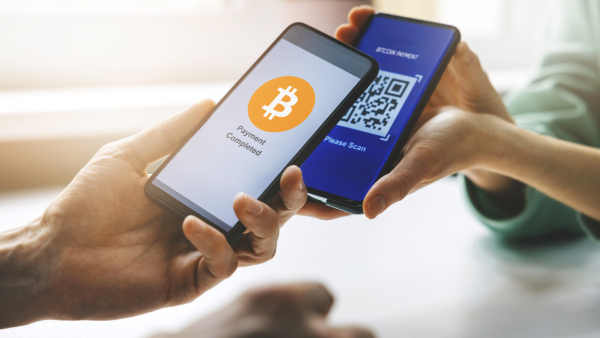 bitcoin payment - person using smart phone to pay with crypro