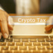Close up of professional hands in suit typing on laptop keyboard with words crypto tax highlighted, representing finance, technology, and digital currency concepts