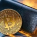 Black wallet with a golden bitcoin emblem, set against a glowing blockchain background, 3D illustration