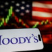 US credit rating agency Moody's Corporation logo on smartphone against US flag and rising stock market candlestick chart concept