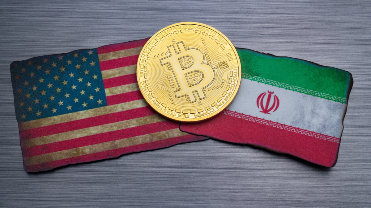 bitcoin token on flags of the United States and Islamic republic of Iran, brushed metal background.